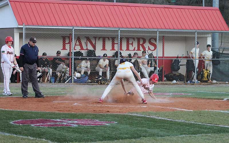 Junior Brock Bradley slides safely into home plate in the first inning of Franklin’s season opener versus Murphy on McConnell field Feb. 26. (Press photo/Will Woolever)