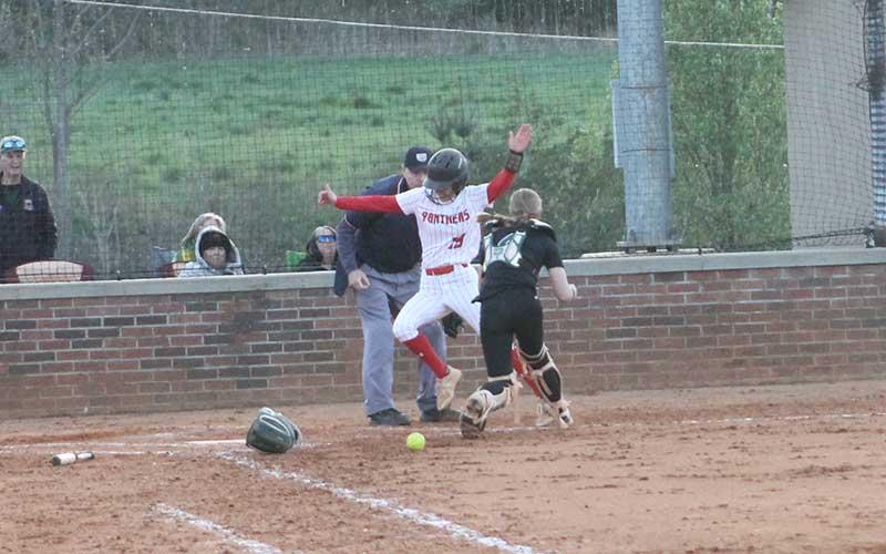 Press photo/Will Woolever - Junior Makayla Pendergrass evades a tag at home plate versus East Henderson April 8. Seemingly unbeknownst to her and the catcher, the ball is still lying on the dirt.