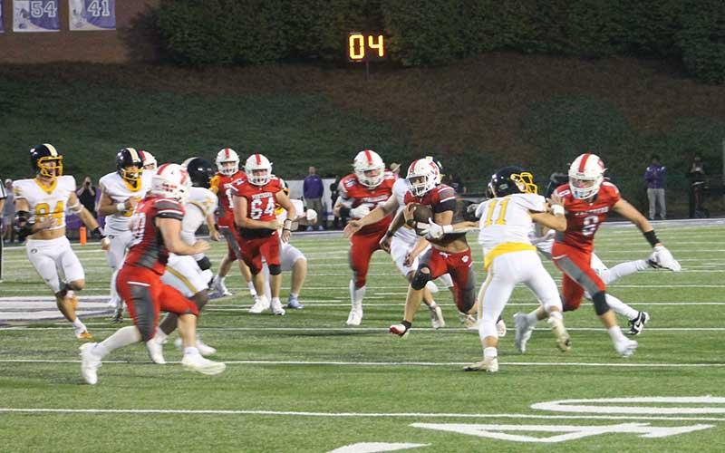 Press photo/Will Woolever - Sophomore fullback Garrett Young (right) carries the ball versus Murphy in Franklin’s season opener at Western Carolina University Aug. 22. Young racked up 125 yards on 27 attempts against the Bulldogs.