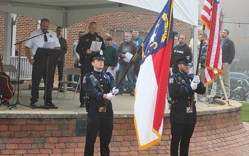 Press photo/Shelby Powell - Franklin Police Officer Jonathan Lauffer and Sgt. Matthew Bingham present flags for the 9/11 memorial service.