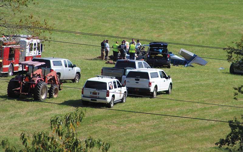 Press photo/Shelby Powell - Emergency personnel respond to a plane crash Thursday afternoon in a field west of Iotla Valley Elementary School. The three people aboard will killed.