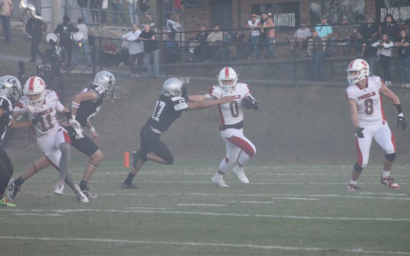Press photo/Will Woolever. Sophomore running back Paxton Sutton stiff-arms a defender on the opening kickoff at Robbinsville Aug. 29.