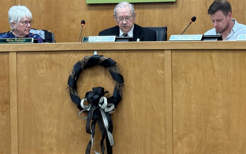 Press photo/Mia Overton - A black-ribboned wreath hangs in the Franklin Town Council board room in memory of former council member Joyce Handley, who passed away Nov. 1. Mayor Jack Horton started the Nov. 3 meeting with a moment of silence honoring Handley.