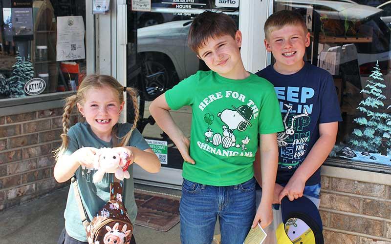 Press photo/Shelby Powell - Kyle Davidek, Caden Davidek and Cooper Creel walk around downtown Franklin looking for history to fill out their “Passport to the Past.”