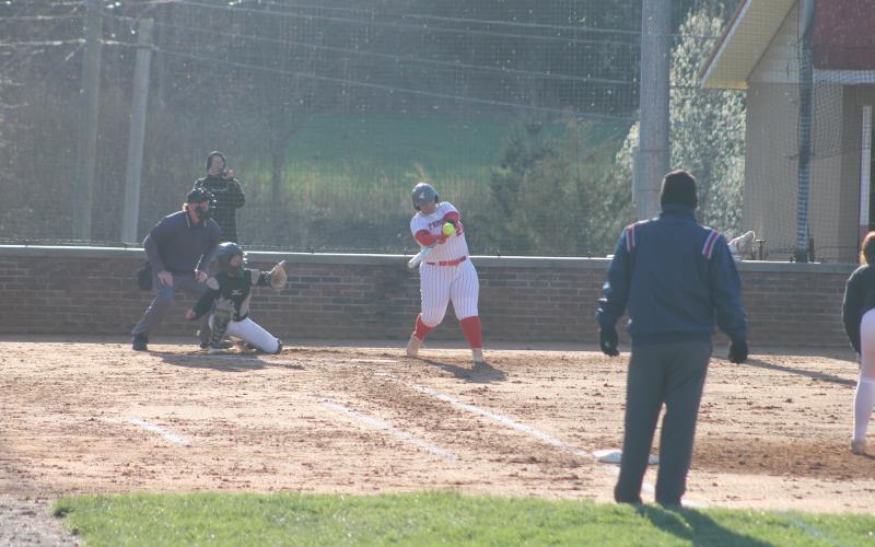Press photo/Will Woolever. Taylor Carrion makes contact with a pitch in a freezing St. Patrick’s Day game versus East Henderson.