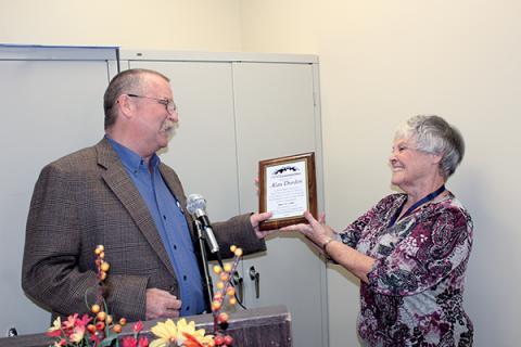 Press photos/Jake Browning - Kathy Kahler presents Alan Durden with a plaque marking his 30 years as cooperative extension director.