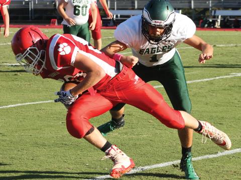 Press photo/Andy Scheidler Tight end Abraham Apel secures the ball after making a catch over the middle and taking a hit from a Flat Rock player in the final game of the season. 