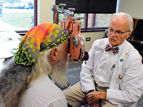Press photo/Linda Mathias - Dr. LeRoy Roberson performs an eye exam for a veteran during Thursday’s Stand Down. 
