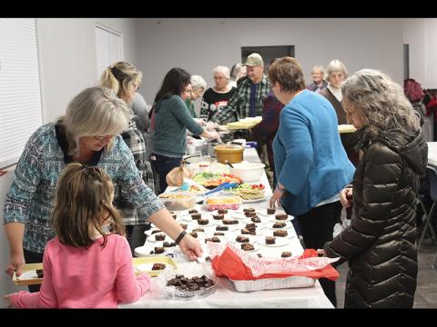 Press photo/Jake Browning Volunteers from Franklin First Assembly fix plates to serve to attendees at the Serving Spoon Dinner the week before Christmas.