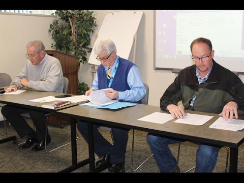 Press photo/Jake Browning Macon County commissioner Gary Shields, left, interim public health director Carmine Rocco and sheriff Robert Holland preside over an appeal on a ruling about a potentially dangerous dog.
