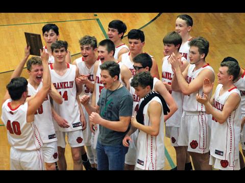 Bradley Stiles (40) holds up the plaque while his teammates react after winning the Mountain Six Conference tournament for junior varsity boys basketball. Franklin went 23-1 this season and dominated Smoky Mountain in the finale. 