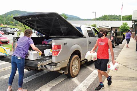 Press photo/Linda Mathias - Volunteers bring food to vehicles lined up at Mountain View Intermediate School on Monday, July 27.