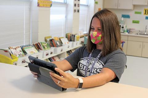 Press photo/Jake Browning Cartoogechaye Elementary School third-grade teacher Katie Kennedy sets up a tablet in preparation for her students’ return on Monday.