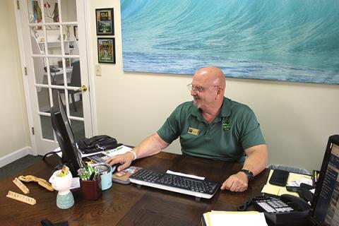 press photo/Will Woolever - Bald Head Realty owner/broker John Becker checks the company website in his Franklin office.