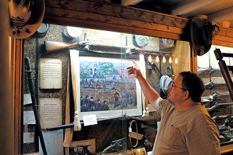 Press photo/Will Woolever - Macon County Historical Museum curator Robert Shook explains the history behind Civil War artifacts in the museum’s collection. The museum will unveil a new exhibit – an original 19th century log cabin – next door to its building in November.