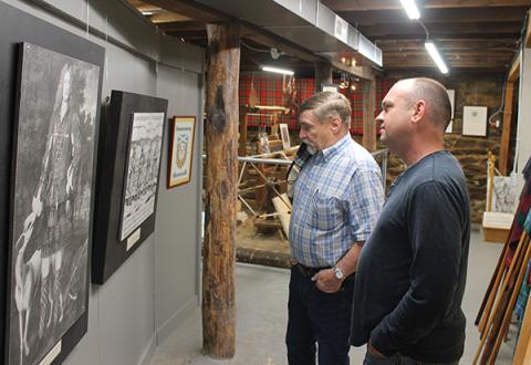 Press photo/Will Woolever - Scottish Tartan Museum director Jim Akins and new Blair Building owner Stacy Guffey examine a piece of artwork in the museum’s basement.