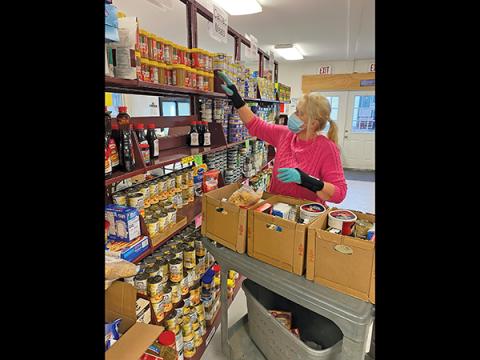 Press photo/Jake Browning - Shirl Frantz helps pack boxes of food for clients at CareNet. CareNet also hopes to distribute plenty of warm winter clothes following Cold for a Cause this weekend.