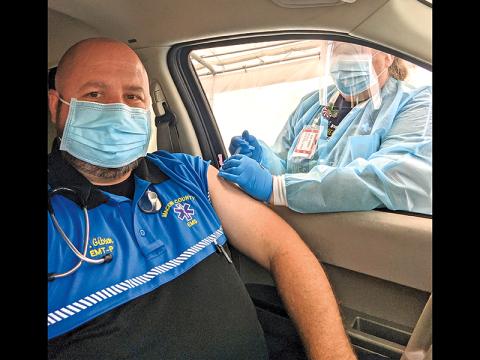 Photo/Macon County Public Health Macon - County EMT Joey Gibson receives his first dose of the Moderna COVID-19 vaccine from Jennifer Garrett, the county’s director of nursing.