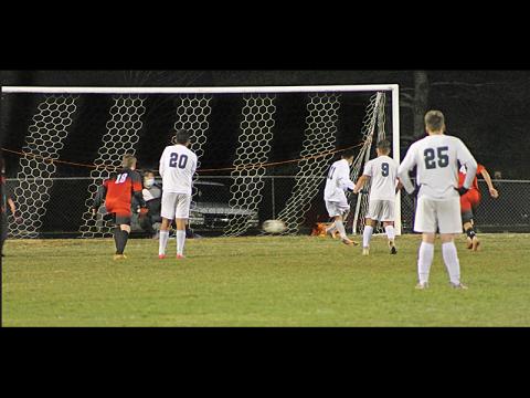 Press Photo/Will Woolever - Franklin goalkeeper Isaac Jennings dives for a penalty kick against East Henderson while freshman midfielder Jaydon Pevia looks on. Jennings saved the shot to give Franklin a 1-0 win over the Eagles.