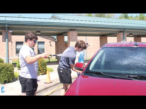 Press photo/Jake Browning - Franklin High School students Gavin Awtrey, Bryce Rogers and Blaine Doolittle wash teachers’ cars at Cartoogechaye Elementary School as part of North Carolina’s Teacher Appreciation Week.