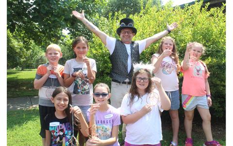 Press photo/Jake Browning Luis Fernandez and several of his students after finishing the first project of the Greenway art class lineup, a small tree sculpture made of stone and copper.