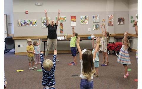 Press photo/Jake Browning - Kim Terrell leads her class at the library in a few warmup exercises before they start on the day’s nutrition lesson.