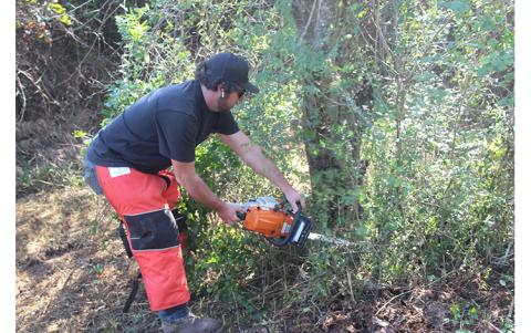 Press photo/Jake Browning - Tyler Payne of Carolina Underbrushing clears vegetation at the future site of the Barbara McRae Cherokee Heritage Apple Trail. The trail will be located at the half-mile marker on the north end of the Little Tennessee River Greenway.