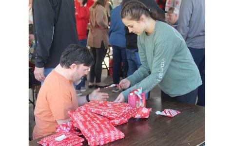 Press photo/Jake Browning - Mike (left) gets a Christmas gift from Abby Carpenter at Macon Citizens Habilities’ Christmas party.
