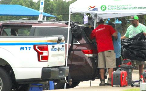 Photo/The Wilson Times A Honda Odyssey van is vacuumed after gunfire shattered its back window at the Gillette Athletic Complex on Sunday morning. 