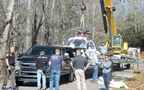 Press photo/Thomas Sherrill A recovery crew prepares to transport the helicopter that crashed March 9 on Middle Burningtown Road. (Note: The rotors were removed from the helicopter to prepare it for transportation.) Two representatives from the Federal Aviation Administration’s Charlotte office were on site Friday investigating, according to Macon County Emergency Services. The cause of the crash remains under investigation and a representative from Erlanger Health System said it could be “some time” before
