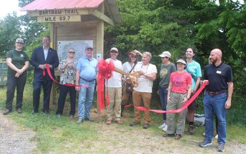 Press photo/Thomas Sherrill - Brent Martin, executive director of the Blue Ridge Bartram Trail Conservancy, cuts the ribbon for the new kiosk and re-route of the Bartram Trail through Franklin during a June 7 ceremony.