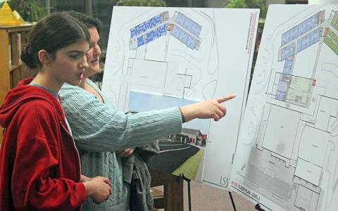 Press photo/Thomas Sherrill - Irene and Faith Lefebvre, 13, look at the Franklin High School new building renderings after a focus group on Wednesday, March 6.