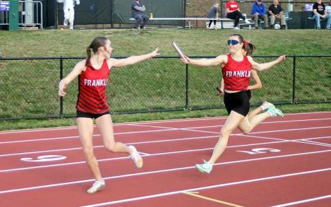Press photo/Will Woolever - Freshman Audrey Pressley (left) takes the baton from senior Rylee Cassada in the women’s 4x200-meter relay at Western Carolina University March 7. 