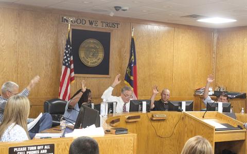 Press photo/Thomas Sherrill. All five Macon County commissioners vote in favor of funding the Macon Middle School track during the May 14 meeting.