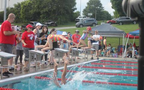 Press photo/Will Woolever - (From left) Kendall Adams, Leah Delgado and Emmie Monteith dive off their blocks for the girls 8 & under 100-yard individual medley at the Macon county Rec Park June 13.