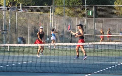 Press photo/Will Woolever - #1 doubles partners Maci Stork (left) and Kate Phillips look a ball in versus West Henderson Sept. 9.