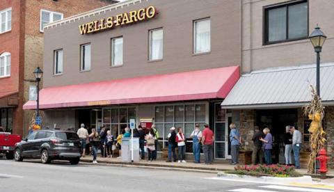 Photo/Bob Scott - People wait outside Wells Fargo. Many banks and businesses were offline the first part of the week and could only process cash transactions. As service is restored people will once again be able to use their debit and credit cards.