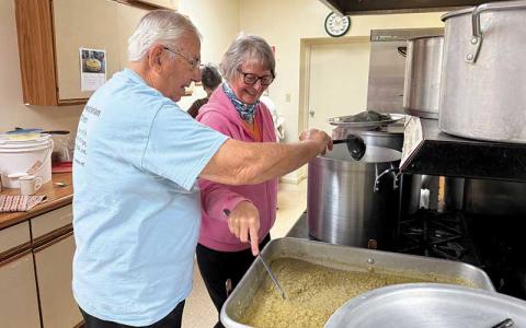 Press photo/Mia Overton - Jim McInnes and Sandy Geary prepare food for First Presbyterian Church’s free Thanksgiving meal. The church will begin serving at noon on Thursday.