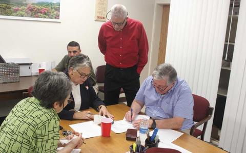 Press photo/Thomas Sherrill - The Macon County Board of Elections members read off the early-voting results from the ticker tape prior to entering them into the statewide database. Pictured (from left) are Board of Elections members Lynne Garrison, Chair Kathy Tinsley, John Vanhook and Vice Chair Gary Dills while Sheriff Brent Holbrooks looks on.