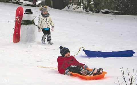 Photo/Bob Scott - Harper and Ty Moser play in the snow during a visit with their grandparents on Maple Street.