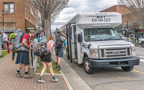 Photo/Bob Scott - Hikers board a Macon County Transit van during a previous hiker season. The MCT Hiker Route shuttles hikers from the Appalachian Trail at Winding Stair Gap and Rock Gap to various locations around town.