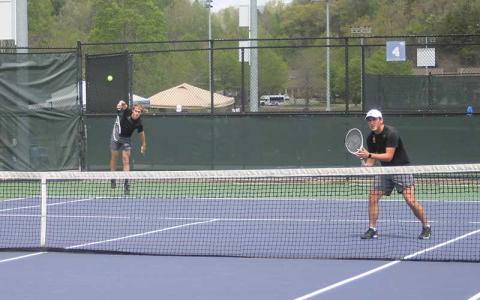 Press photo/Will Woolever - Gavin Rinker serves to Pisgah while Eli Adams guards the net in the Mountain Seven Conference Doubles Semifinals April 23.