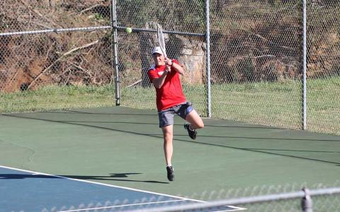 Press photo/Will Woolever - Senior Eli Adams returns a high-bouncing shot versus Smoky Mountain April 9.