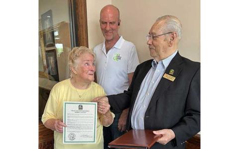 Photo submitted - Franklin Mayor Jack Horton presents a resolution to Bobbie Contino, recognizing her for 40 years as executive director of the Macon County Arts Council. Council member Nate Anderson stands in the background. 