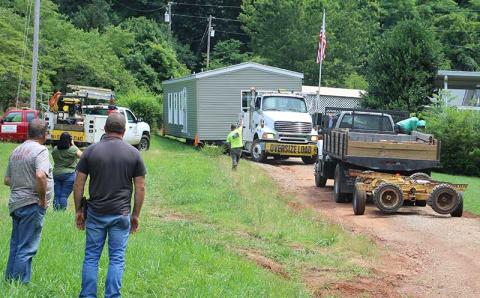 Press photo/Shelby Powell - Workers maneuver a double-wide prebuilt house into a lot to replace a home lost to Hurricane Helene damage, letting Madeline Maynard move back onto the mountain after nine months without a home. 