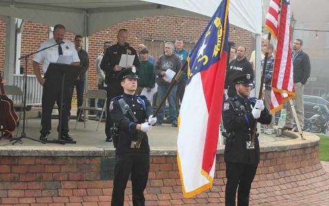Press photo/Shelby Powell - Franklin Police Officer Jonathan Lauffer and Sgt. Matthew Bingham present flags for the 9/11 memorial service.