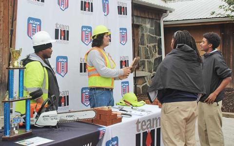 Press photo/Shelby Powell - Logan Dennis (left) and Alejandro Martinez (right) talk to Job Corps guests about masonry tools.
