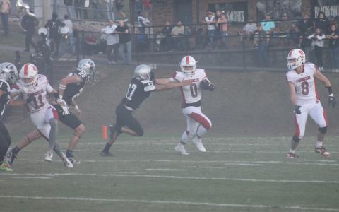 Press photo/Will Woolever. Sophomore running back Paxton Sutton stiff-arms a defender on the opening kickoff at Robbinsville Aug. 29.