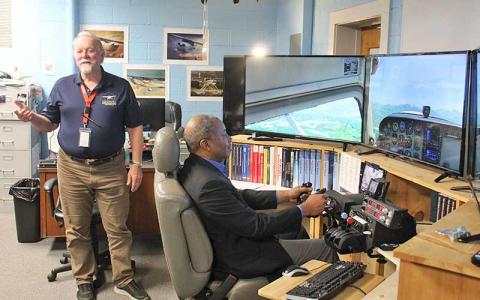 Press photo/Shelby Powell - FHS aviation teacher Scott Hanna (left) discusses the high school’s aviation program while State Superintendent Mo Green tries out a flight simulator.