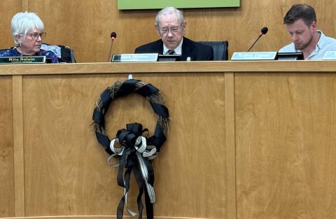 Press photo/Mia Overton - A black-ribboned wreath hangs in the Franklin Town Council board room in memory of former council member Joyce Handley, who passed away Nov. 1. Mayor Jack Horton started the Nov. 3 meeting with a moment of silence honoring Handley. 